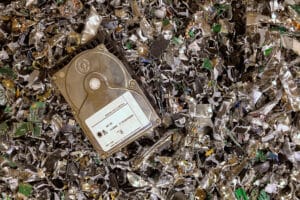 A hard drive resting on a pile of shredded hard drives