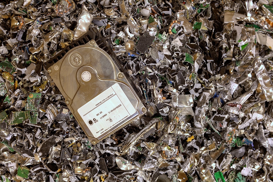 A hard drive resting on a pile of shredded hard drives