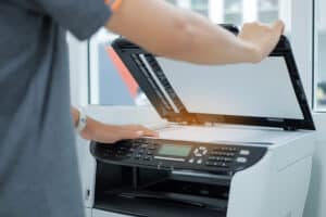 Bussiness woman Hand putting a document paper into printer scanner or laser copy machine in office